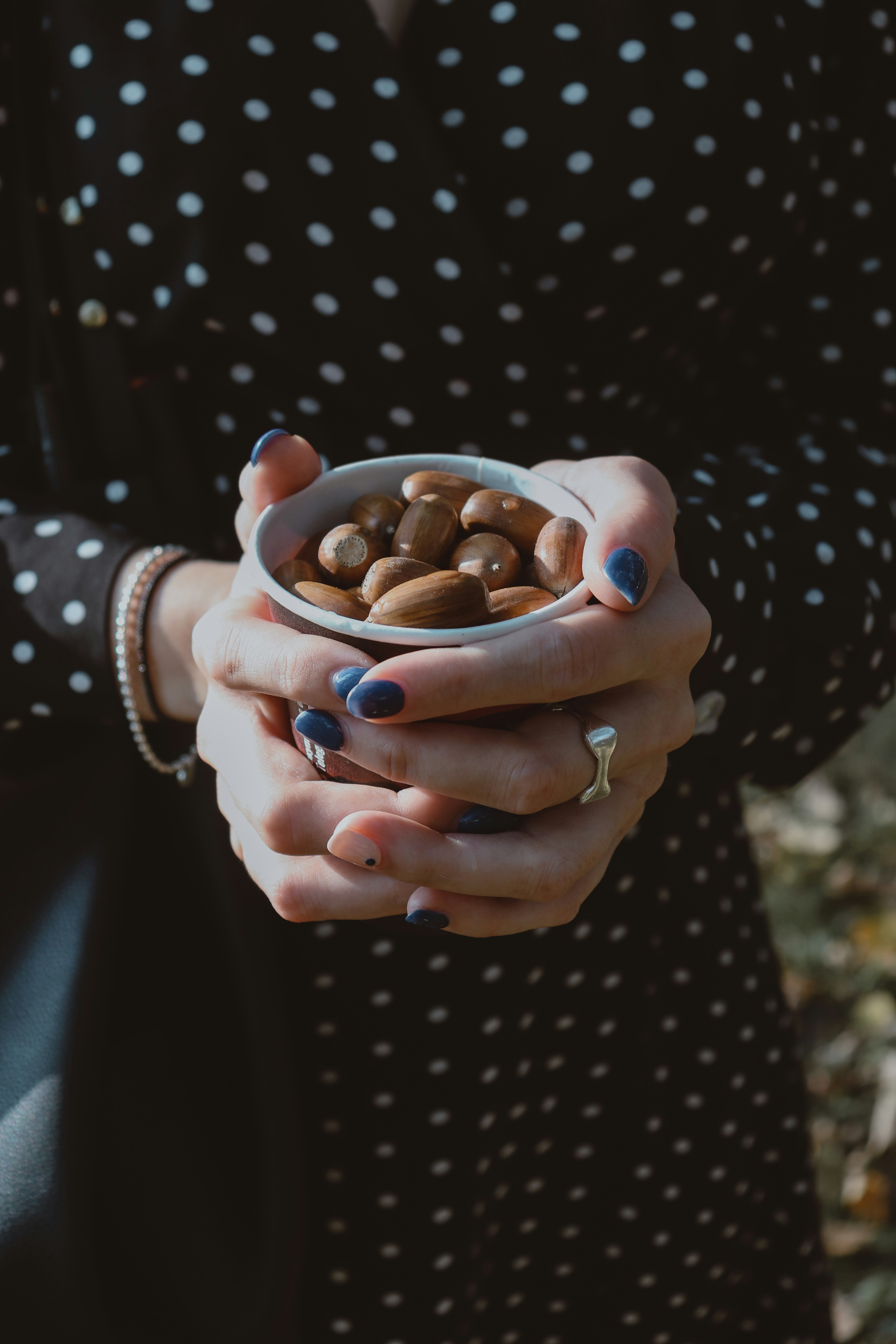 person holding white ceramic mug with brown liquid